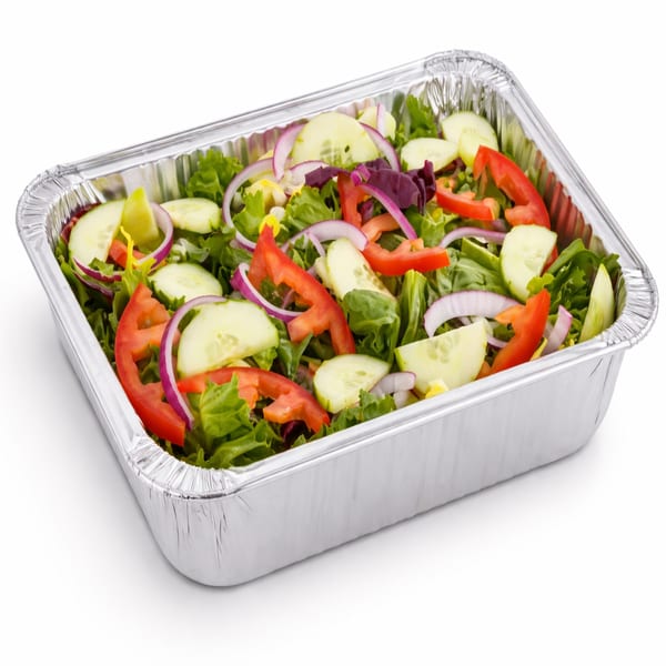 Fresh garden salad with lettuce, cucumbers, red onions, and bell peppers in a foil container.